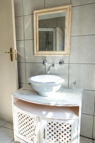 a bathroom with a white sink and a mirror at Hidden Grace in Parys