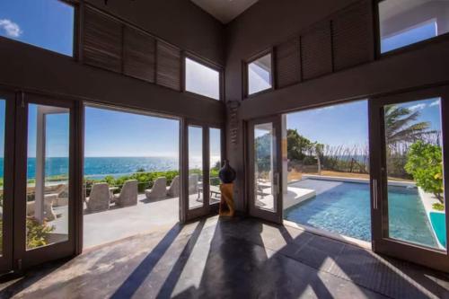 a house with a view of the ocean and a swimming pool at Cloud 11 Jamaica in Treasure Beach
