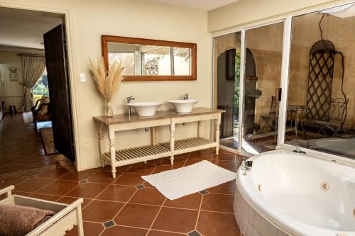 a bathroom with two sinks and a tub at Hidden Grace in Parys