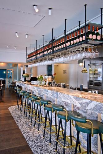 a bar with green stools in a restaurant at Clubhaus Bachmair Weissach in Tegernsee