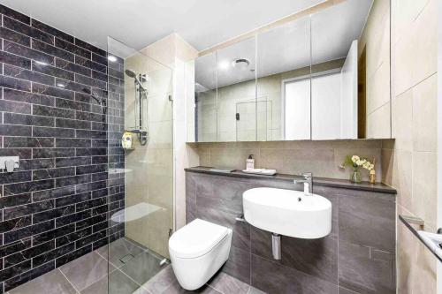 Un baño con un lavabo blanco y un inodoro. en Sun-filled Apt w Stunning Open Views of Park&City, en Sídney