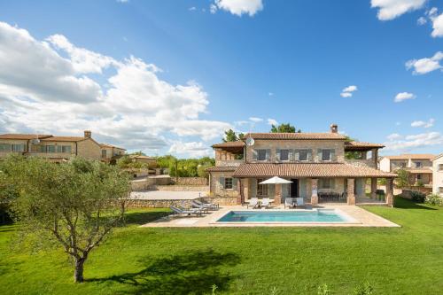 uma casa grande com uma piscina num quintal em Villas Sv. Lovrec by Istarski Dvori em Sveti Lovreč Pazenatički