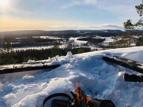 bañera de hidromasaje con chimenea en la nieve en Northern Lights exclusive house by the river en Boden