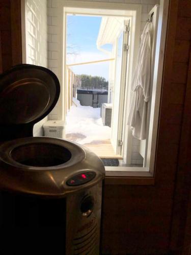 a bathroom with a sink and an open door at Northern Lights exclusive house by the river in Boden