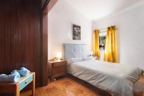 - une chambre avec un lit et un rideau jaune dans l'établissement Vivienda V Torres 1, à Vega de San Mateo