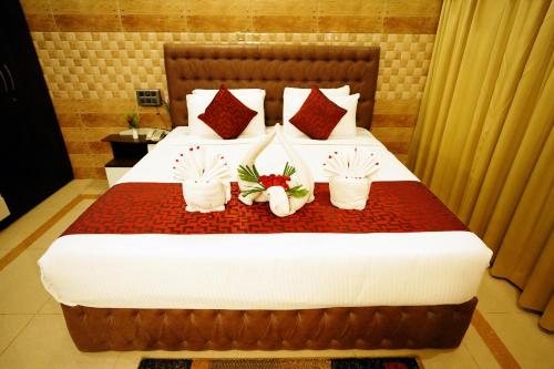 a hotel room with a bed with three plants on it at Jal Mahal Resort and Spa in Mysore