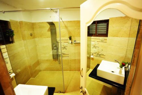 a bathroom with a shower and a sink at Jal Mahal Resort and Spa in Mysore