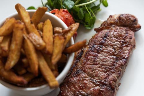 a plate with steak and french fries and a salad at The White Swan Inn in Pickering