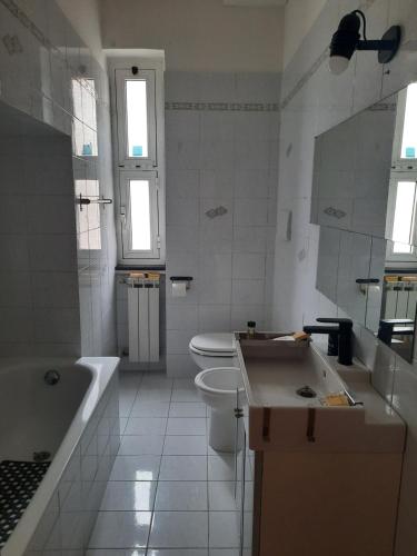 een badkamer met een bad, een toilet en een wastafel bij NEREA house in Lido di Ostia