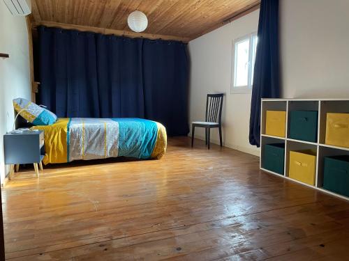 ein Schlafzimmer mit einem Bett und einem blauen Vorhang in der Unterkunft Appartement cosy in Massignieu-de-Rives