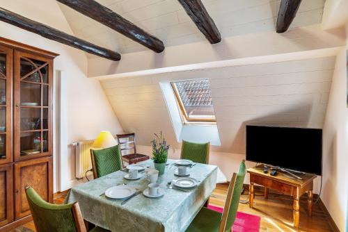 a dining room with a table and chairs and a television at Ferienwohnung Blaues Haus in Ubstadt-Weiher