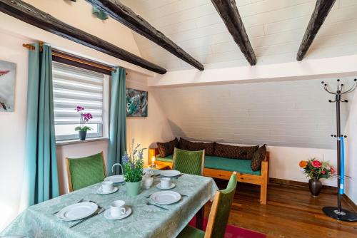 a dining room with a table and chairs and a couch at Ferienwohnung Blaues Haus in Ubstadt-Weiher