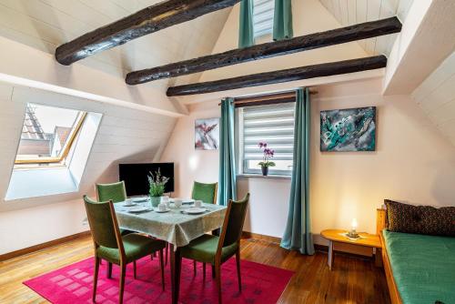 a dining room with a table and green chairs at Ferienwohnung Blaues Haus in Ubstadt-Weiher