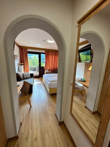 a living room with a bed and a mirror at Landhotel Maiergschwendt inkl Chiemgaukarte in Ruhpolding