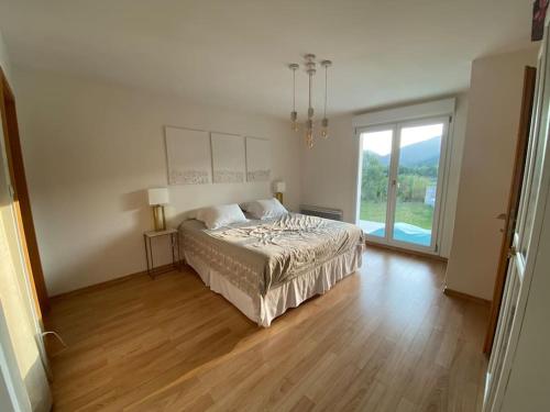 a bedroom with a bed and a large window at Villa des Cloisieures in Saint-Amé