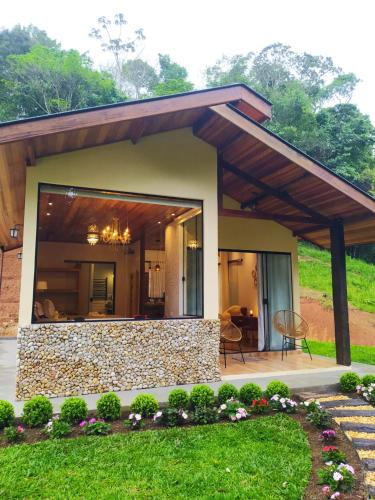 a house with a large window and a patio at Chalé Refúgio Bem-Te-Vi in São Bento do Sapucaí