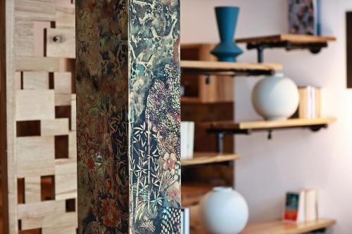 a room with shelves with vases and a pole at 36 Phô Cô Hotel & Suites in Weimar
