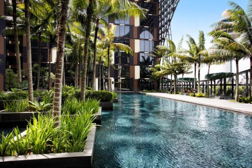 an infinity pool with palm trees in a building at Crowne Plaza Changi Airport by IHG in Singapore