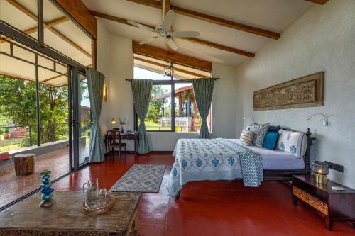 a bedroom with a bed and a living room at SaffronStays Satori Aves, Ultra Luxe Cottages On 8 Acres Estate, By The Mulshi Lake in Mulshi