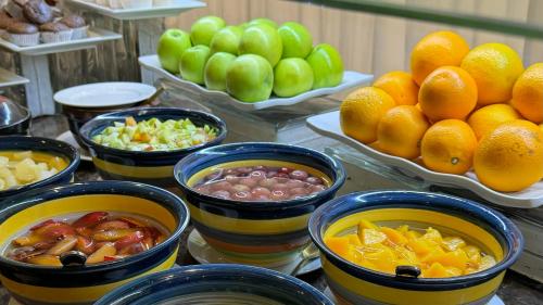 a buffet with bowls of fruit on a table at Merkure Jeddah Al Hamraa Hotel in Jeddah