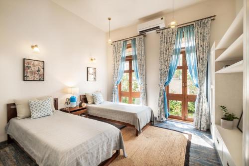 a bedroom with two beds and a window at LohonoStays Villa Sobreda in Bardez