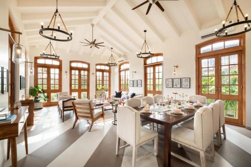 a dining room with a long table and chairs at LohonoStays Villa Sobreda in Bardez