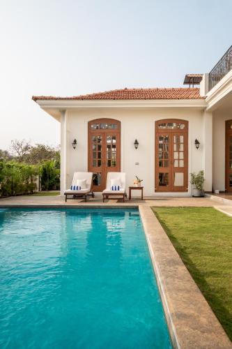 a swimming pool in front of a house at LohonoStays Villa Sobreda in Bardez