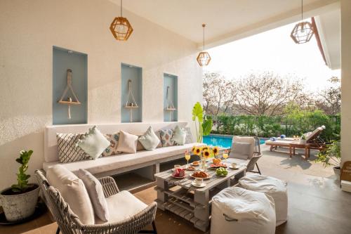 a living room with a couch and chairs and a table at LohonoStays Villa Sobreda in Bardez