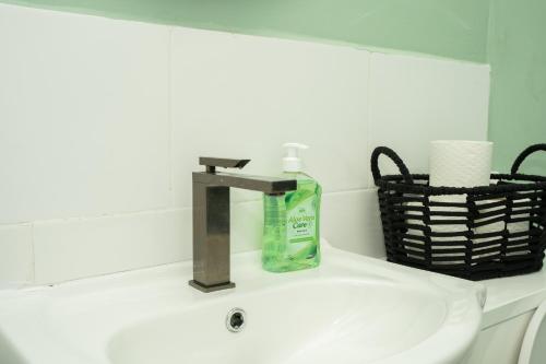 un lavandino in bagno con una bottiglia di sapone di Peaceful home Nr Roundhay Park a Moortown