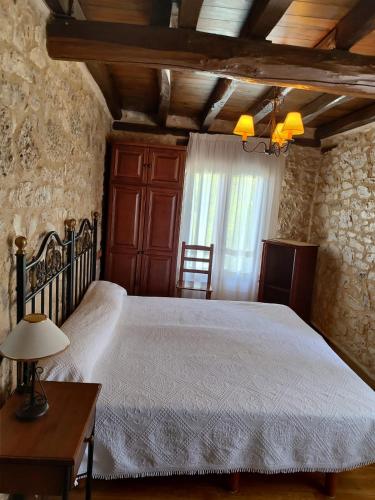 a bedroom with a bed and a table and a window at La casa de Aza in Haza