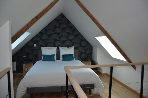 una camera da letto con letto bianco in mansarda di Lebeau Repos a Plouër-sur-Rance