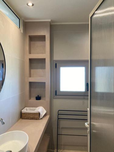 a bathroom with a sink and a window at Pnoe Eco Residences in Amalias