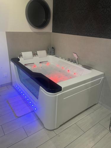 a white tub with lights in a room at Appartement avec jacuzzi in Sassenage