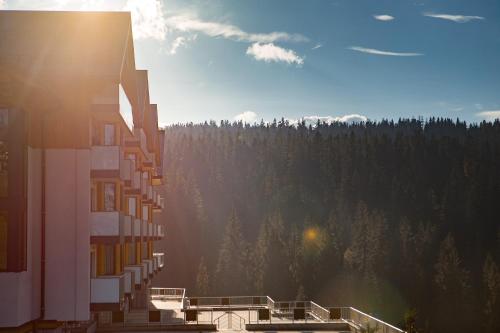 a building with a view of a forest of trees at Hotel BUKOVINA in Bukowina Tatrzańska
