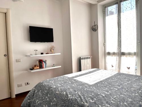 um quarto com uma cama e uma televisão na parede em Apartment in Arzela em La Spezia