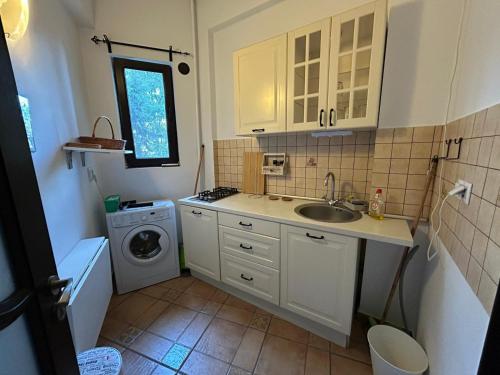 a small kitchen with a sink and a washing machine at Romana Square Studio in Bucharest