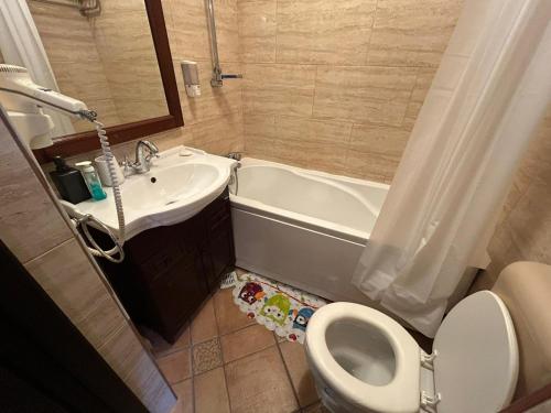 a bathroom with a sink and a tub and a toilet at Romana Square Studio in Bucharest