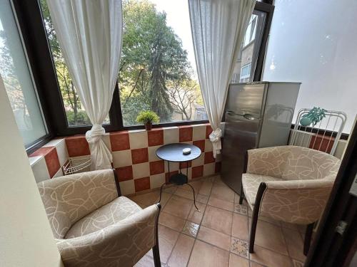 a room with two chairs and a table and windows at Romana Square Studio in Bucharest