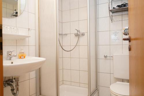 uma casa de banho com um chuveiro, um WC e um lavatório. em Yildirim Touristik Wohnung L&L 7 em Duhnen