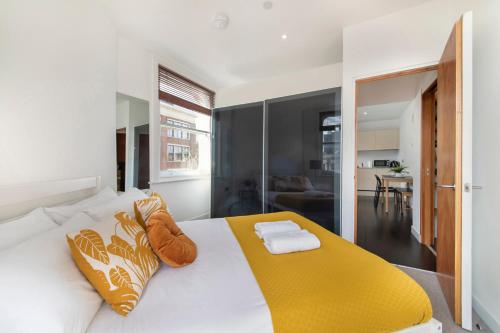 1 dormitorio con 1 cama blanca con manta amarilla en Luxury Central London Apartment - Farringdon, en Londres