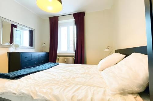 Un dormitorio con una gran cama blanca y una ventana en City center apartment in middle of Bratislava, en Bratislava