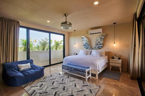 1 dormitorio con cama, silla y ventana grande en Spacious & Comfy Penthouse Oasis with Plunge Pool, en Tulum