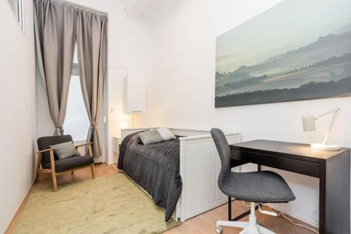 1 dormitorio con escritorio, 1 cama, escritorio y silla en Newly furnished apartment for up to 6 people, en Berlín