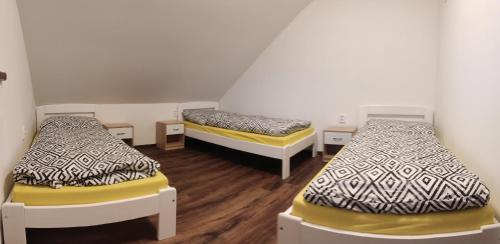2 camas num quarto com pisos em madeira em Penzion Bystřička em Vsetín