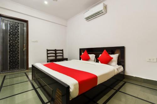 a bedroom with a large bed with red pillows at OYO Flagship Hotel Sawraj Regency in Sohāna