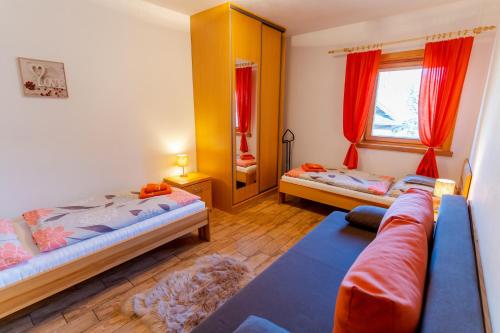 ein Schlafzimmer mit zwei Betten und einem Sofa darin in der Unterkunft Apartmány Skihouse Jasná in Demänovská Dolina