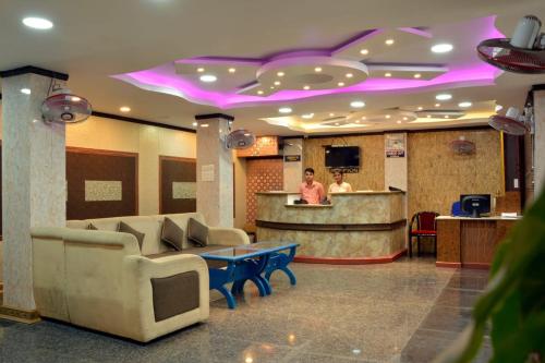 a man standing at a bar in a hotel lobby at Sree Karpagam Dreams in Port Blair