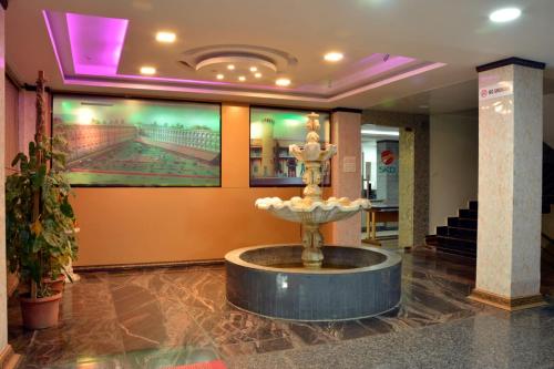 a lobby with a fountain in the middle of a building at Sree Karpagam Dreams in Port Blair