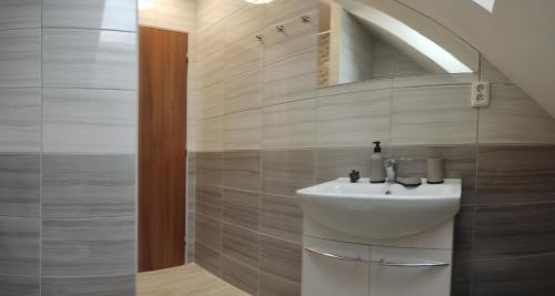 uma casa de banho com um lavatório e um espelho em Penzion Bystřička em Vsetín