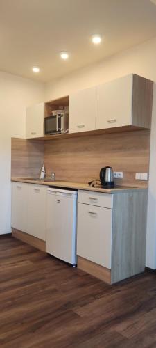 a kitchen with white cabinets and a counter top at Penzion Bystřička in Vsetín